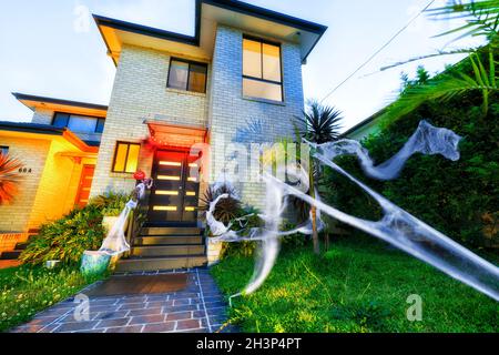 Spider webs, pumpkins, witches, lighs decorating facade of a residential house in Sydney for Halloween. Stock Photo