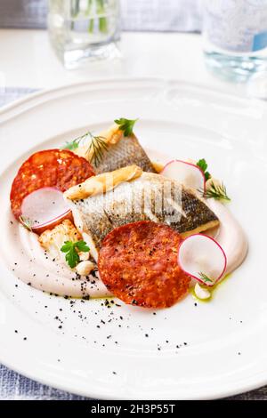 Pike perch fillet with chorizo, cauliflower and radish in a restaurant serving. Close up. Stock Photo