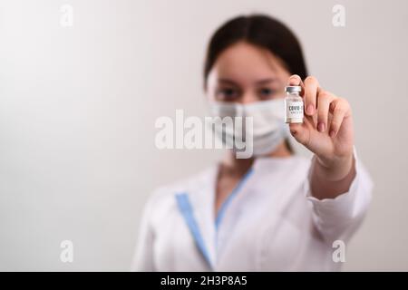The doctor holds the vaccine in his hands. The laboratory presents a ready-made coronavirus vaccine. Stock Photo