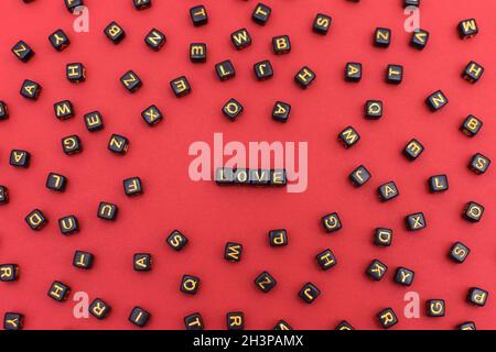 Word love spelled in blocks in the centre on a red background. There are a lot of letters on black cubes around. Stock Photo