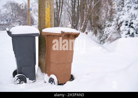 Garbage cans at the roadside on a snowed-in street in Magdeburg in Germany Stock Photo