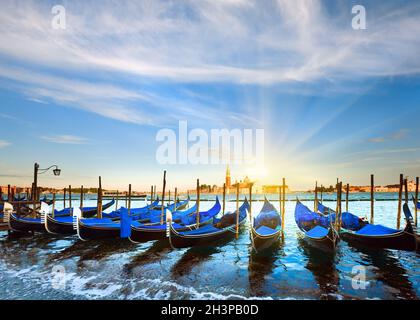 Parked gondolas on Piazza San Marco and The Doge Palace embankment and sunset sunshine (Venice, Italy) Stock Photo