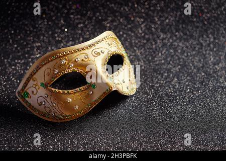 Festive, colorful Mardi Gras or carnivale mask on golden background. Venetian masks. Stock Photo