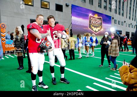 Carson Daly and Willie Geist, dress as American Footballers Rob Gronkowski  and Tom Brady respectively, show off real Superbowl championship rings on  the 'Today' TV show Halloween special at Rockefeller Centre. (Photo