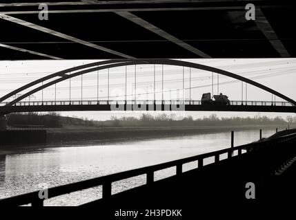 View of an arch bridge from a viewpoint below a highway bridge in Magdeburg in Germany Stock Photo