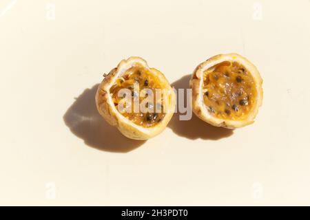 Yellow passion fruit or Passiflora edulis sliced in half against a white background Stock Photo