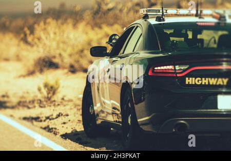 California Highway Patrol Cruiser on Side of a Desert Highway. United States of America. Police Theme. Stock Photo