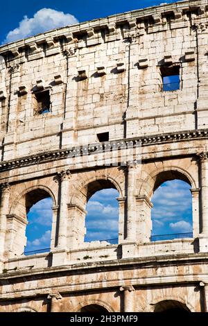 Rome, Italy. Arches archictecture of Colosseum exterior with blue sky background and clouds. Stock Photo