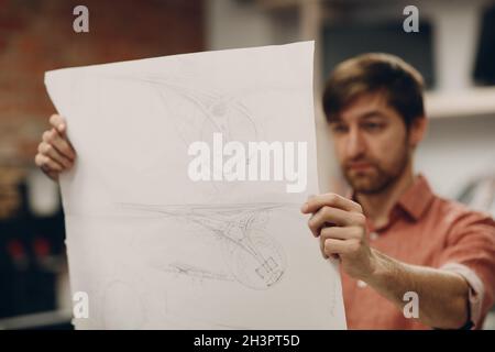 Architect holds in hands blueprints and layout design project at office Stock Photo