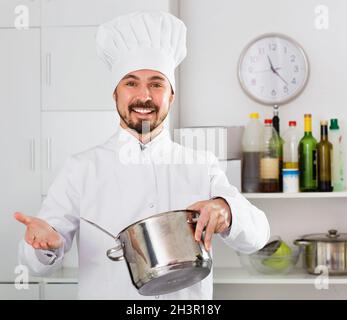 Smiling man cook making tasty dishes in kitchen Stock Photo