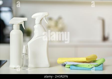 Clean up. Close up shot of detergent bottles and stack of rugs on kitchen surface Stock Photo