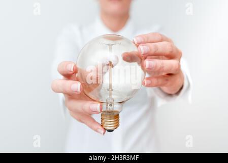 Lady Holding Lamp With Formal Outfit Presenting New Ideas For Project, Business Woman Showing Bulb With Two Hands Exhibiting New Stock Photo
