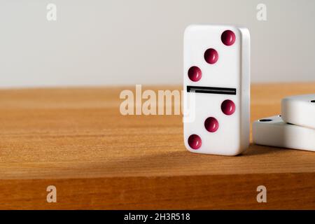 White domino dice standing on wooden table close up Stock Photo