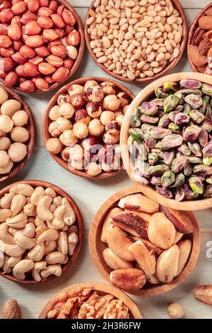 Many different nuts in wooden bowls, overhead shot Stock Photo
