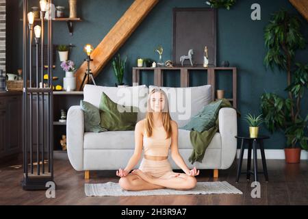 Young woman having online yoga session at home Stock Photo