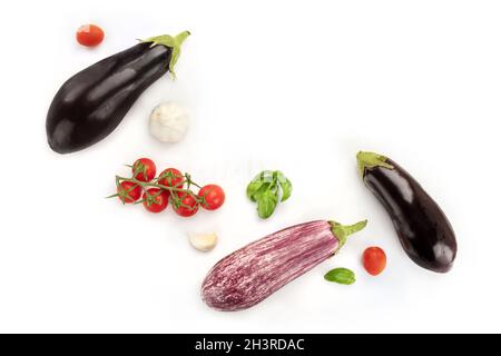 A flat lay composition with vegetables. Eggplants, tomatoes, basil leaves, and garlic Stock Photo