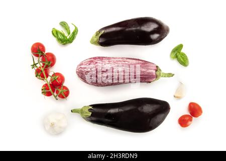 A flat lay composition with vegetables. Eggplants, tomatoes, basil leaves and garlic Stock Photo
