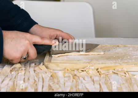 Close-up of the process of making homemade pasta. Female chef prepares fresh traditional Italian pasta Stock Photo