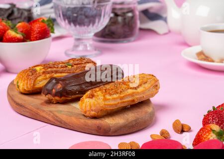 Home made cake eclairs on pink table Stock Photo