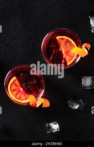 Negroni cocktails with orange rind, shot from the top with ice cubes
