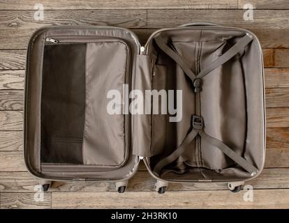 Open suitcase isolated on old wooden background Stock Photo
