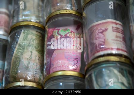 World currencies currently in use or obsolete. Banknotes placed in glass jars. Numismatics is the collection of coins or banknotes. Stock Photo