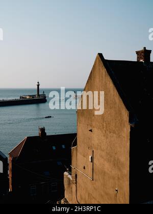 The 199 Steps view of Whitby Harbour West Lighthouse and the architecture of East Cliff in Whitby North Yorkshire England UK Stock Photo