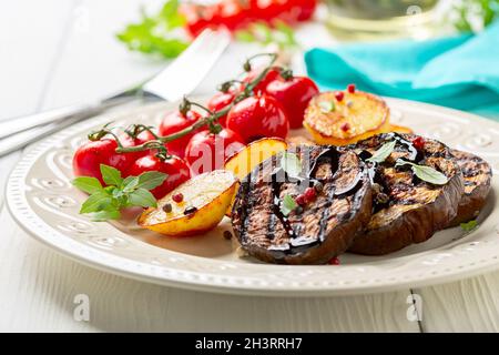 Grilled eggplant steaks with vegetables. Stock Photo
