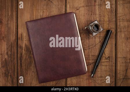 A leather bound journal, and ink well and pen Stock Photo