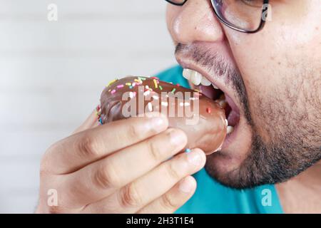 close up of young man eating donut , Stock Photo