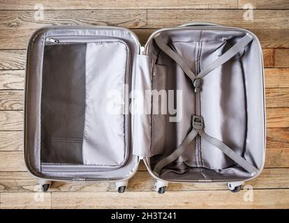 Open suitcase isolated on old wooden background Stock Photo