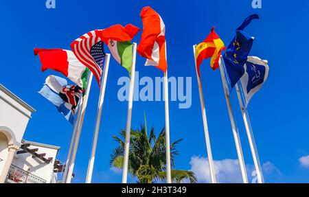 Flags of many countries like argentina spain united states canada italy and europe with blue sky and palm trees in Playa del Carmen Mexico. Stock Photo