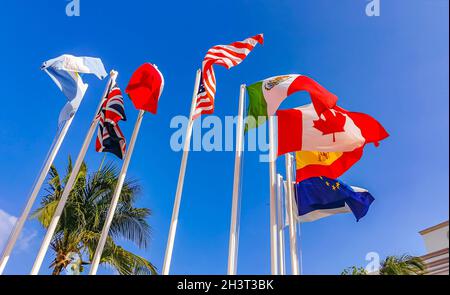 Flags of many countries like argentina spain united states canada italy and europe with blue sky and palm trees in Playa del Carmen Mexico. Stock Photo