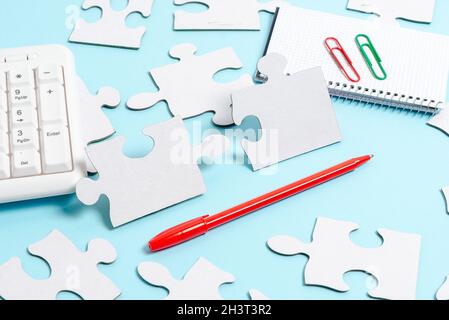 Close-Up White Jigsaw Pattern Puzzle Pieces To Be Connected With Missing Last Piece Positioned On A Flat Lay Background With Dif Stock Photo