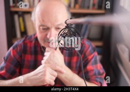 Smiling old elder grandfather talking to webcam on video chat sit at home Stock Photo