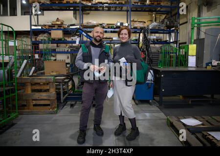 Industrial workers with face masks protected against corona virus discussing about production in factory. People working during Stock Photo