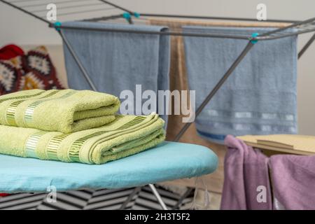Housework concept. Ironing towels on ironing board Stock Photo