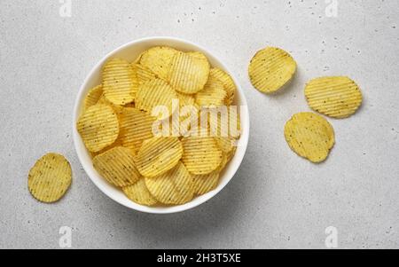 Ridged potato chips in bowl, top view Stock Photo