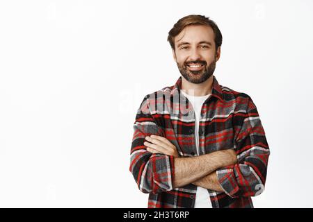 Image of confident man with long beard, cross arms on his chest, real professional, standing in checked shirt over white background Stock Photo