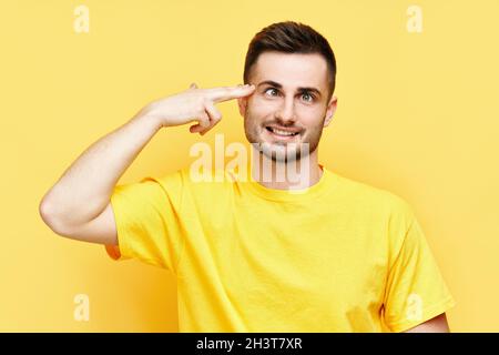 Portrait of a handsome man showing gun gesture with fingers isolated on ...