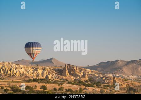 GOREME, TURKEY - AUGUST 5, 2021: One lonely colorful hot air balloon flying over the Cappadocia valley in the morning light