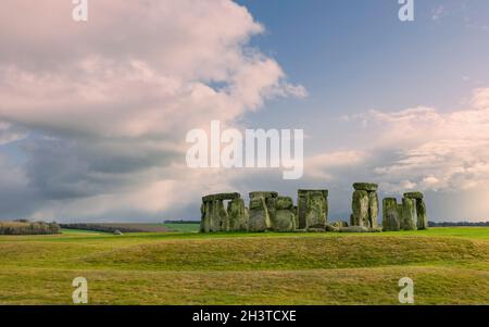 Stonehenge, prehistoric monument, surrounded by grassland and under sunny cloudy skyin winter and no people at Amesbury, Wiltshire, UK. Stock Photo
