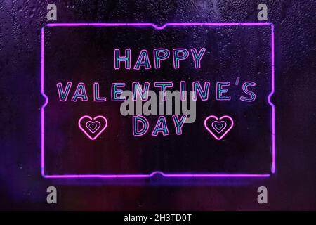 Happy Valentine's Day Pink and Purple Neon Sign in Rainy Window Stock Photo