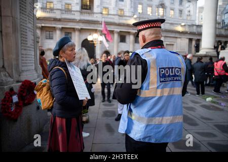 London, UK. 29th Oct, 2021. An activist seen talking to the policeman during the protest. Climate activists staged a Climate Justice Memorial outside the Bank of England as part of the international campaign ahead of the COP26 climate change conference in Glasgow, calling on the bank to stop fossil fuel financing and be responsible to stop the climate change. Credit: SOPA Images Limited/Alamy Live News Stock Photo