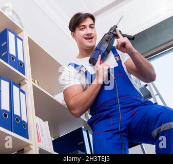 Young worker repairing shelves in office Stock Photo