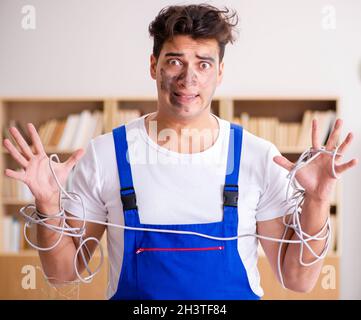 Funny Man doing electrical repairs at home Stock Photo