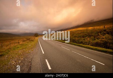 Sunrise on the A4086 between Capel Curig and Pen-y-Pass in Snowdonia National Park, Wales UK Stock Photo