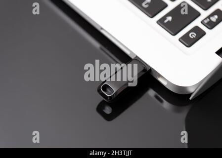 USB flash drive connected to the laptop's USB socket. Pen drive, flash memory concept Stock Photo