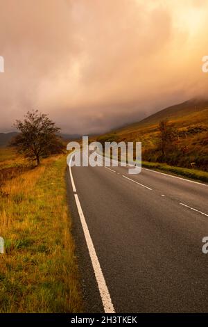 Sunrise on the A4086 between Capel Curig and Pen-y-Pass in Snowdonia National Park, Wales UK Stock Photo