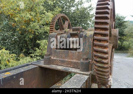 an old mechanical metal gears mechanism on the abandoned dam Stock Photo